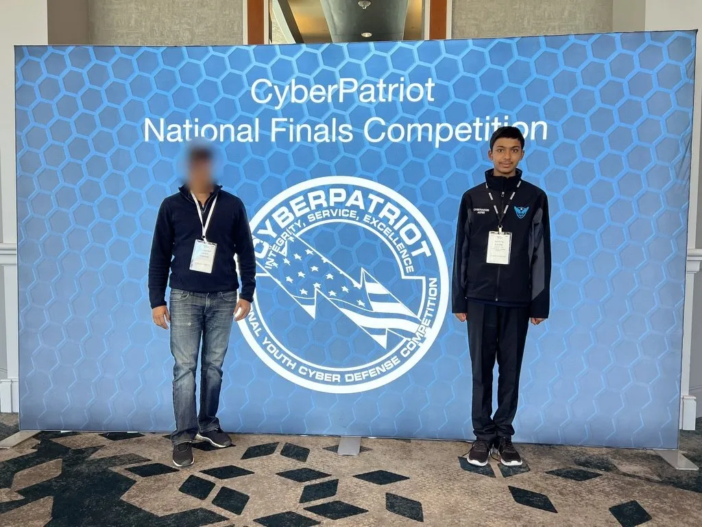 Aditya in front of the CyberPatriot National Finals Competition backdrop