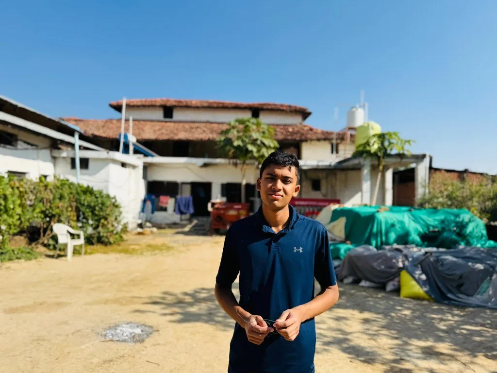 Aditya standing in a courtyard in India
